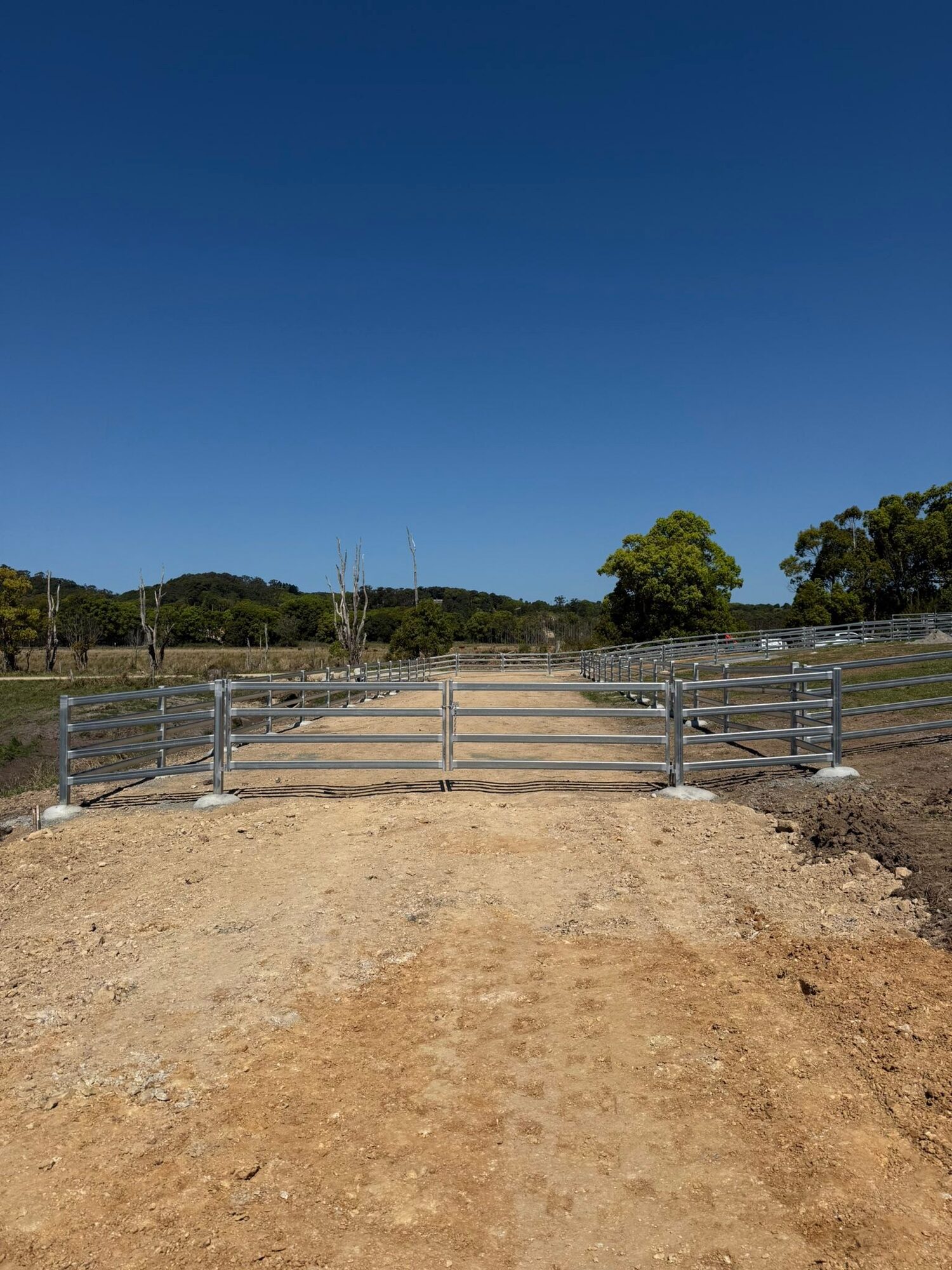 Cattle yard gates and rails installed at a farm entrance